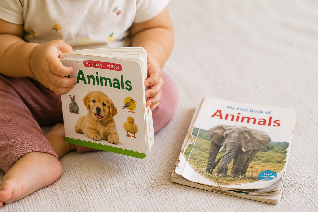 Toddler holding a thick board book with a torn paperback beside it for comparison